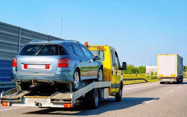 Les Épavistes Pro Les Épavistes Pro Camion de remorquage jaune transportant une voiture sur lautoroute